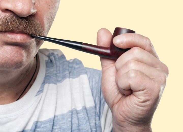 Un homme avec une moustache qui fume
