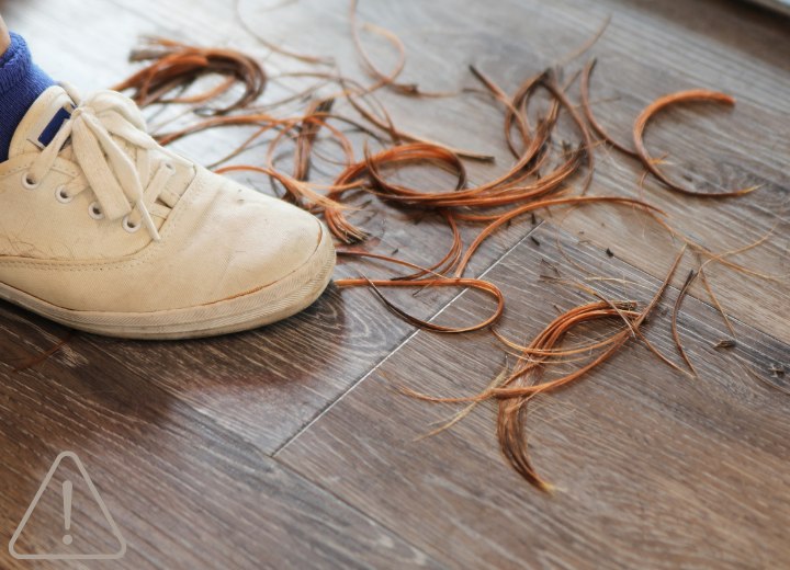 Cheveux coupés tombés sur le sol d'un salon de coiffure