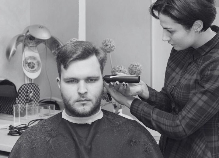 Homme sous une cape de coupe de cheveux